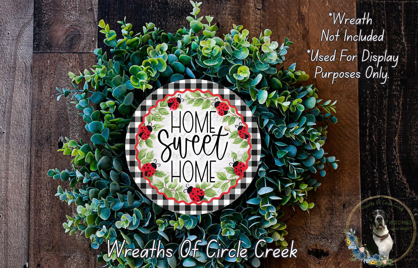 a wreath made of various green plants and flowers, with a decorative sign that reads "Home Sweet Home" in the center.