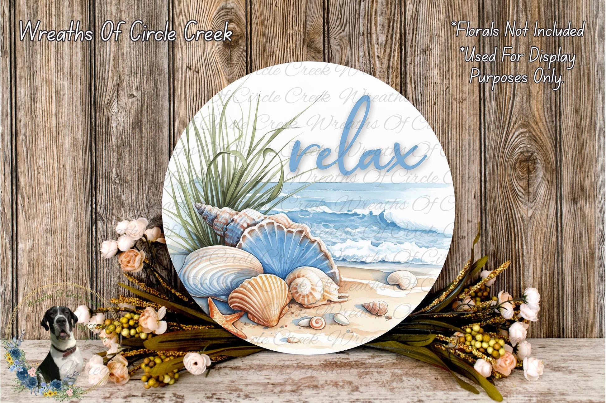 a round wooden plaque with a beach scene and seashells, surrounded by a floral arrangement and a wooden wall.