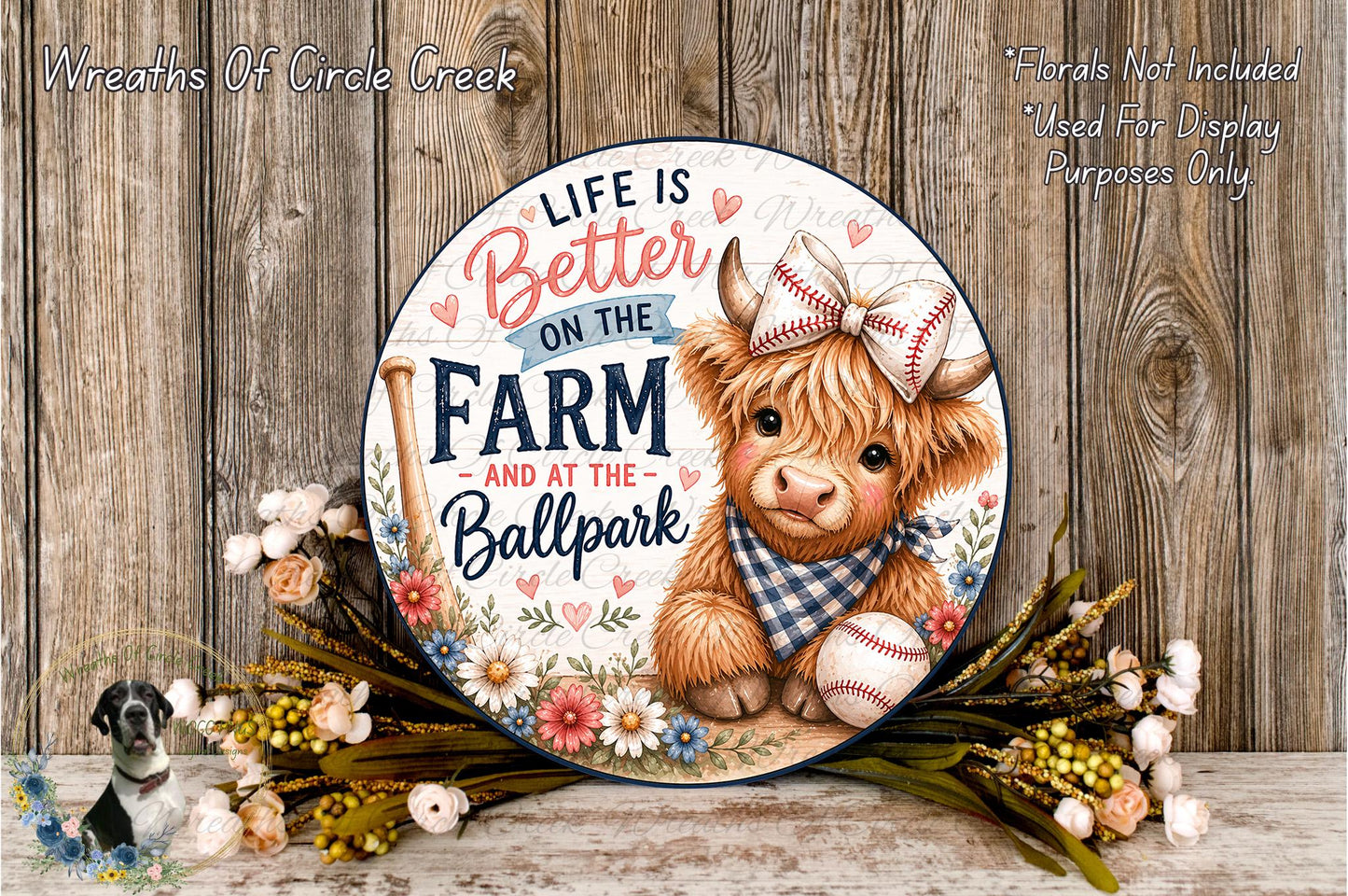 a decorative sign with a cartoon cow wearing a baseball cap and holding a baseball, surrounded by flowers and a wreath. The sign has a message that reads "Life is better on the farm and at the ballpark".
