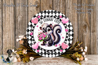a decorative plate with a cartoon image of a skunk holding a bouquet of flowers, surrounded by hearts and flowers. The plate is placed on a wooden surface, and there are additional flowers and heart-shaped decorations around it.