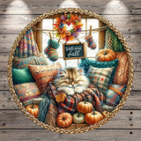 A cozy scene featuring a sleeping cat nestled among autumn-themed pillows and blankets, with a "Welcome Fall" sign hanging above and pumpkins scattered around the room.