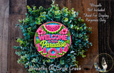 A colorful wreath made of green leaves and flowers, with a large "Welcome to Paradise" sign in the center.