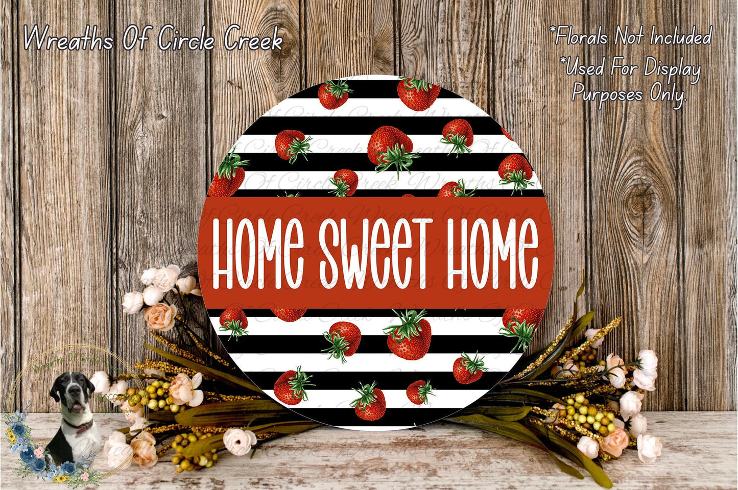 a round sign with the text "HOME SWEET HOME" in bold, red letters, surrounded by a decorative arrangement of flowers and greenery.