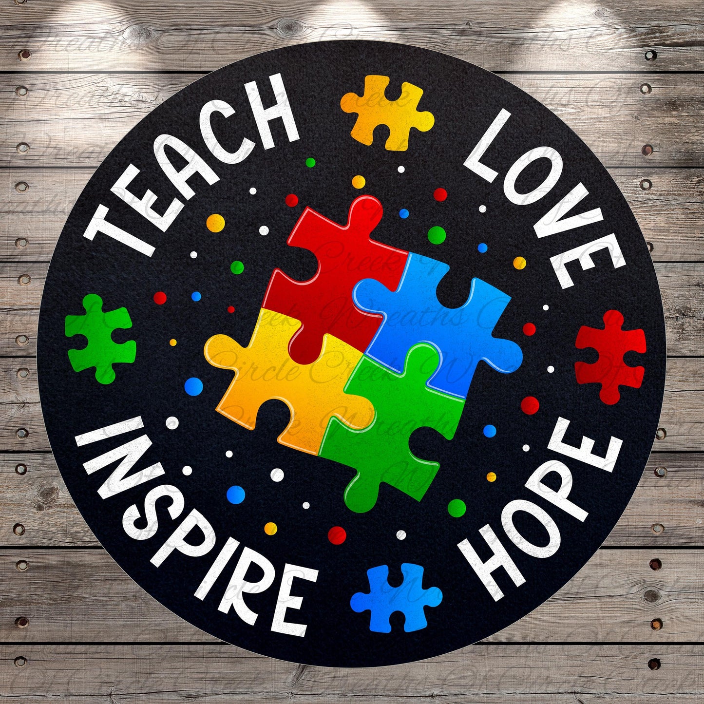 The image is a circular design with the words "TEACH LOVE INSPIRE HOPE" written around the edge. Inside the design, there are puzzle pieces in various colors, including red, yellow, green, blue, and red, arranged in a way that resembles a jigsaw puzzle.