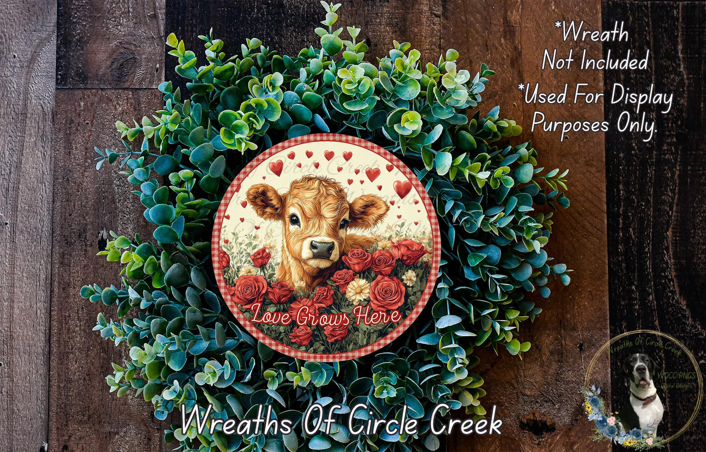 a wreath made of green foliage and red roses, with a cow's head and the text "Love Grows Here" displayed on it.