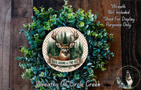 A wreath made of green foliage and a deer head, with the text "Buck Around and Find Out" and "Wreaths of Circle Creek" displayed on it.