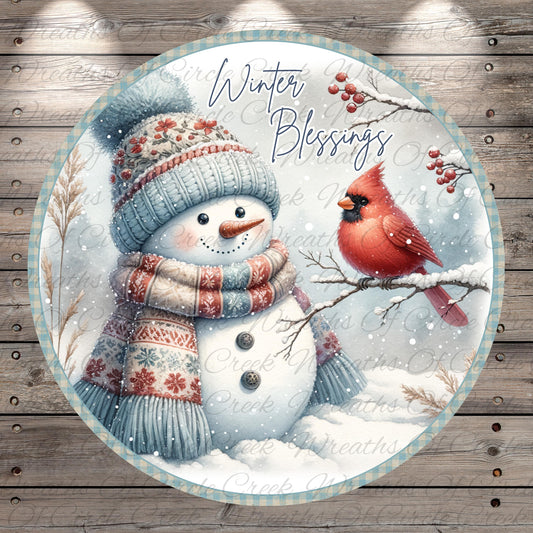 A snowman wearing a colorful scarf and hat stands next to a red cardinal perched on a branch, with snow falling around them. The background features a snowy landscape with trees and berries.