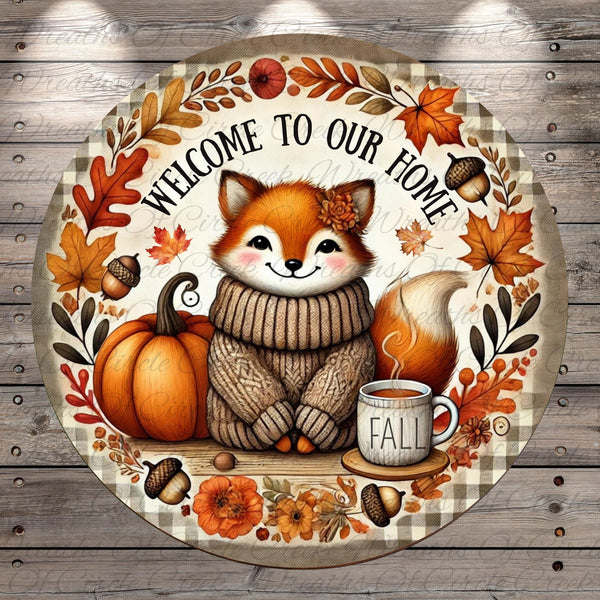 A round, decorative sign featuring a cartoon fox wearing a sweater and surrounded by autumn-themed elements such as leaves, pumpkins, and a cup of coffee.