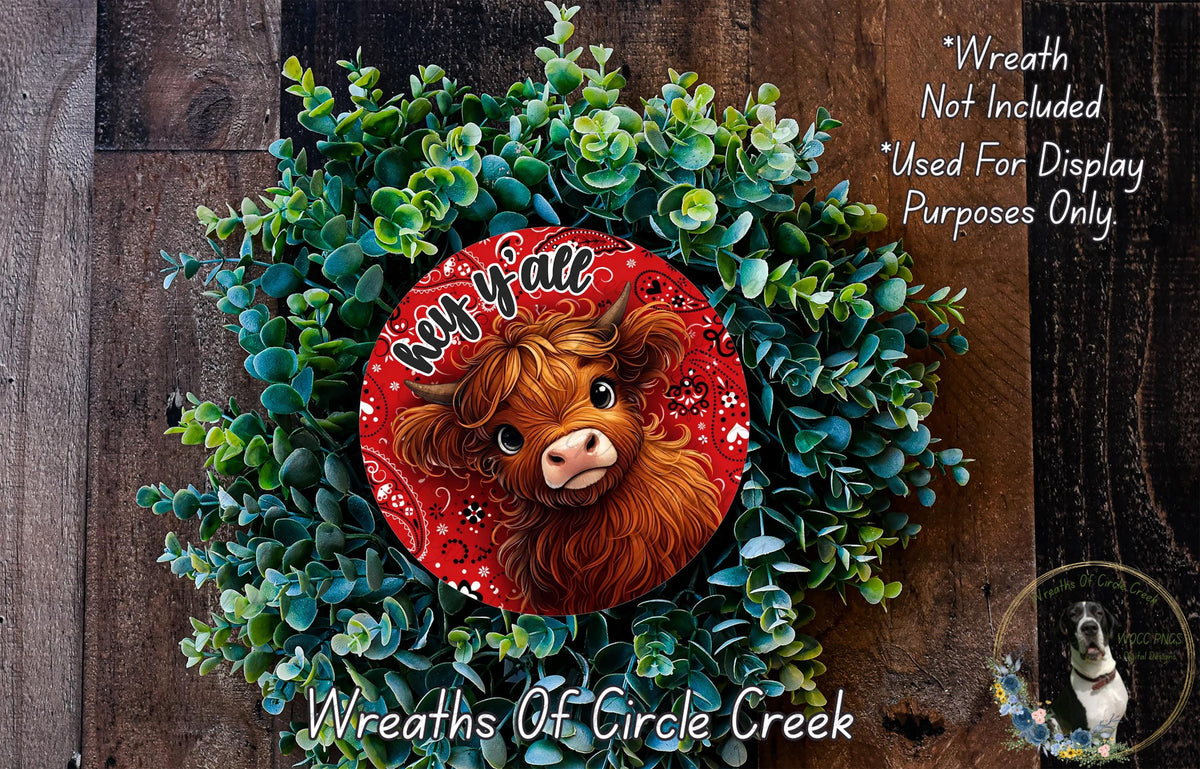 A wreath made of green plants and a red circular ornament featuring a cartoon cow's face.