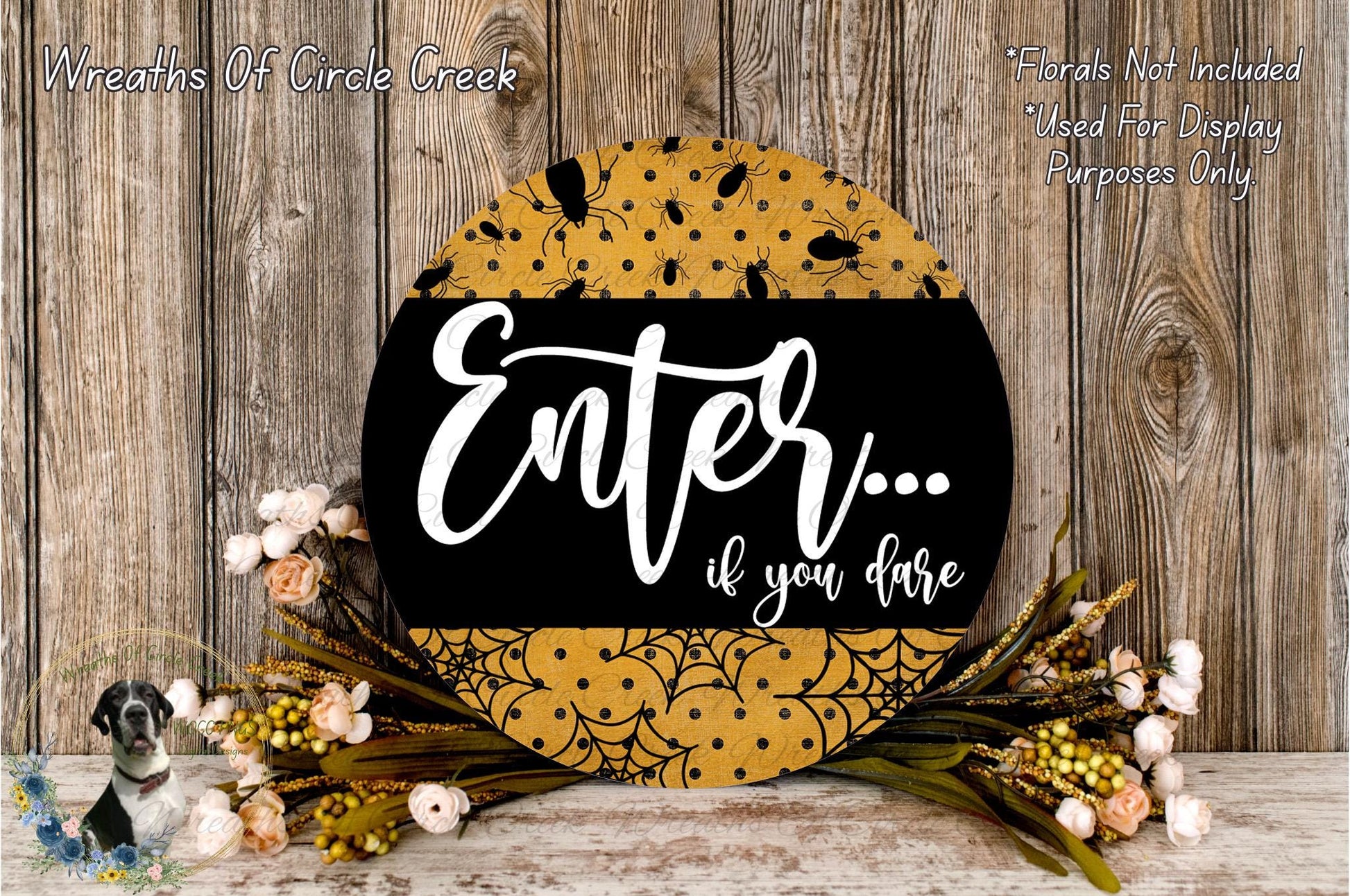 a decorative sign with the text "Enter... if you dare" surrounded by a floral arrangement and a wooden background.