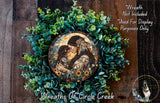 a wreath with a central image of a woman and a child, surrounded by a lush green plant. The wreath is displayed on a wooden surface, and there is a text overlay that reads "Wreath Not Included * Used For Display Purposes Only".