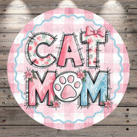 A round graphic with the text "CAT MOM" in a stylized font, surrounded by floral elements and a paw print.
