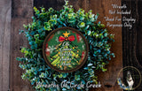 A wreath made of green leaves and a small Christmas tree with a red bow, placed on a wooden surface.