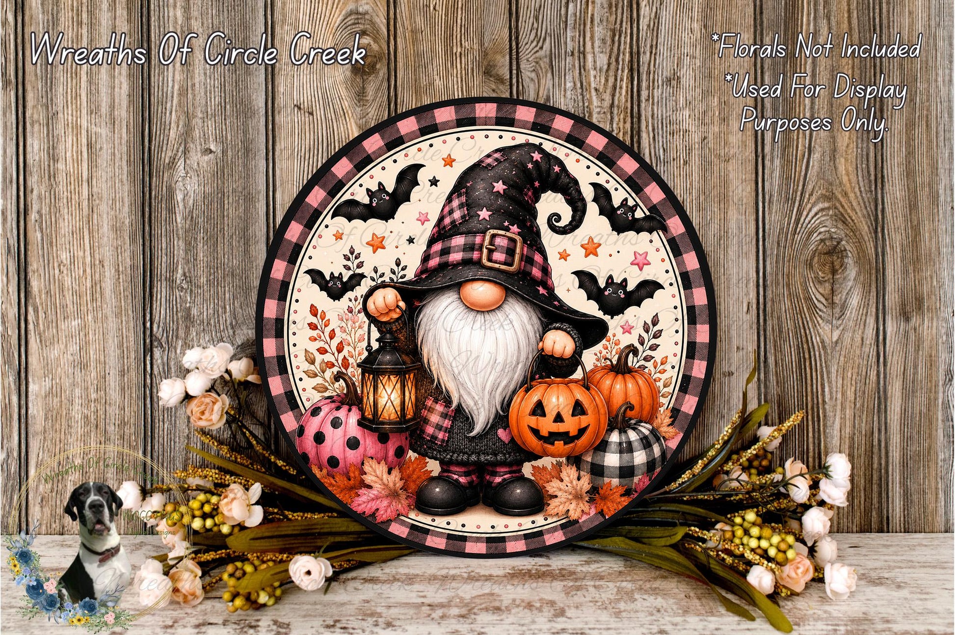 A gnome wearing a black hat and holding a lantern is surrounded by pumpkins, flowers, and bats, creating a festive Halloween scene.