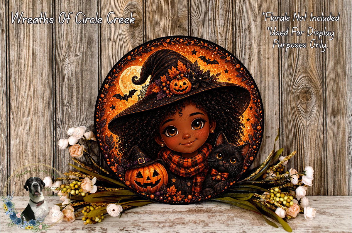 A Halloween-themed wreath featuring a young girl in a witch's hat, holding a pumpkin and a cat, surrounded by flowers and a wooden background.