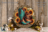 A decorative plate featuring a pair of blue cowboy boots surrounded by sunflowers and leopard print accents, placed on a wooden surface.