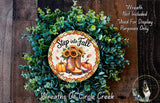 a wreath made of various fall-themed elements, including sunflowers, pumpkins, and boots. The wreath is displayed on a wooden surface, and there is a sign that reads "Step into Fall" and "Wreath Not Included * Used For Display Purposes Only".