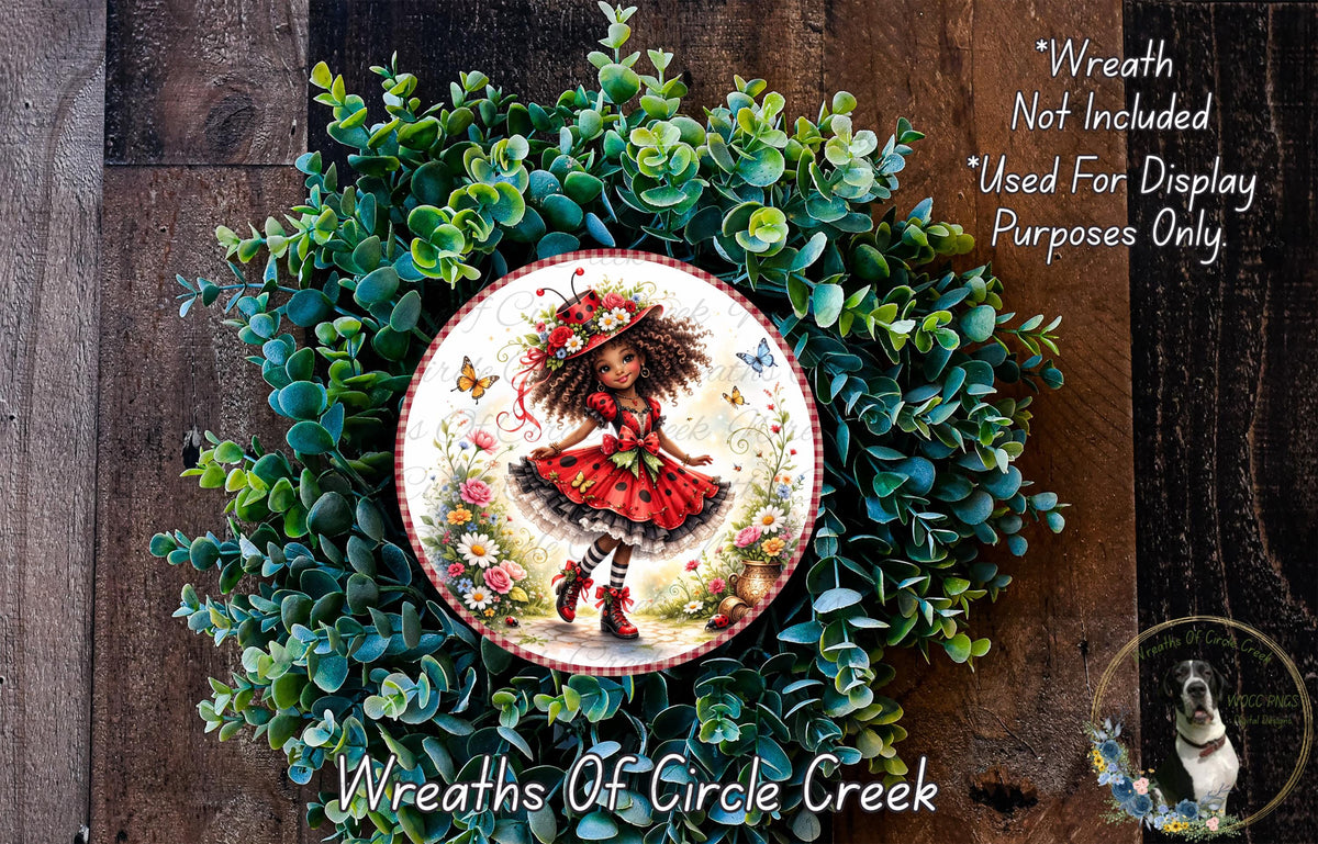 A wreath made of green leaves and flowers, with a circular plate featuring a picture of a young girl wearing a red dress and a flower crown.