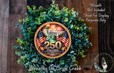 A wreath made of green leaves and featuring a large circular emblem with the number 250 and the Statue of Liberty, surrounded by American flags.