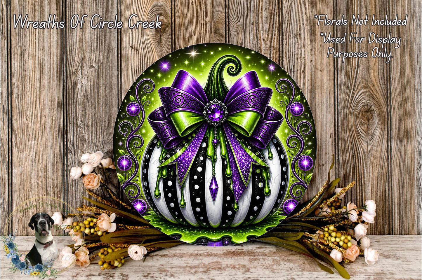 a decorative pumpkin with a purple bow, surrounded by flowers and placed on a wooden surface.