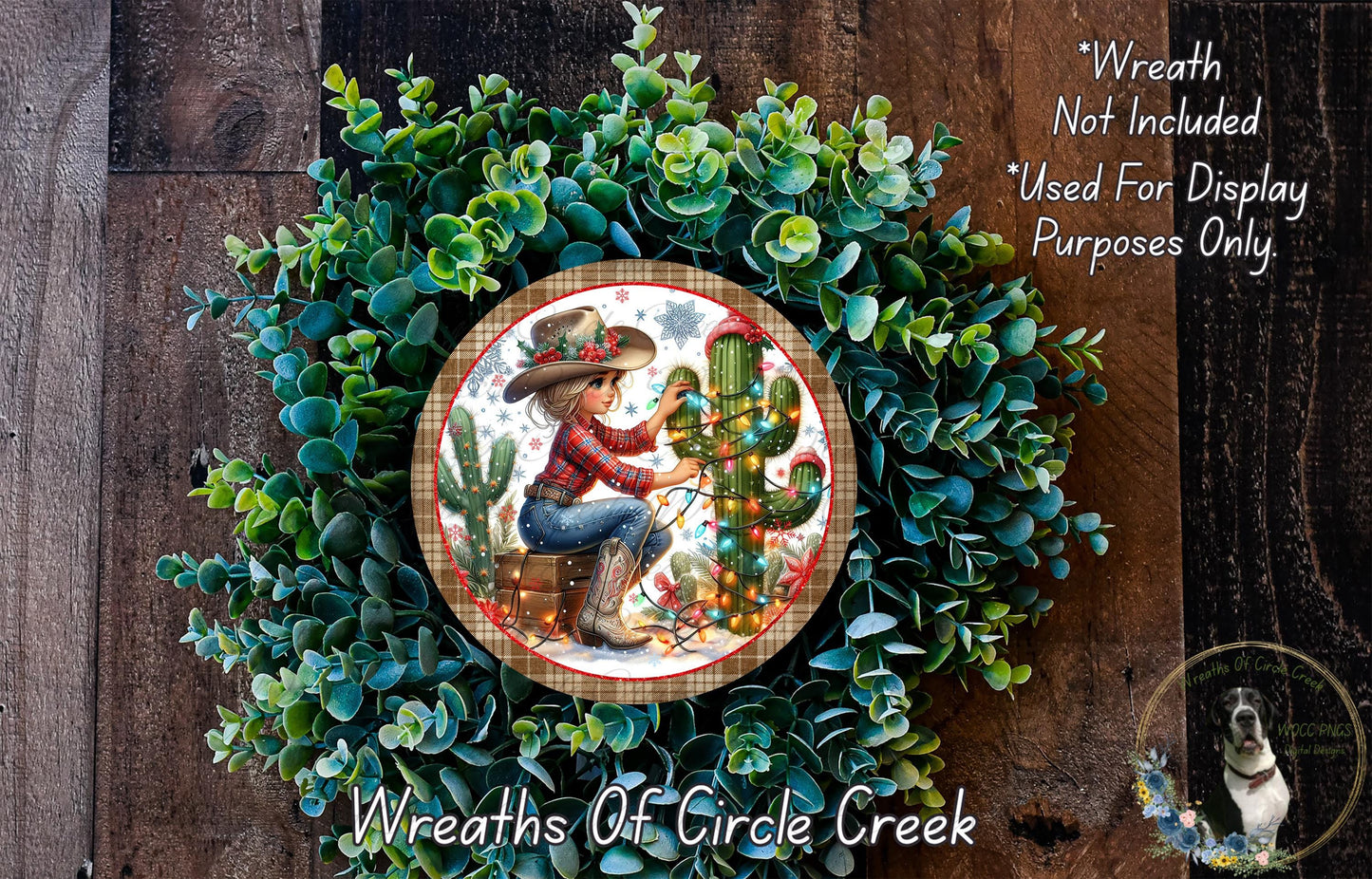 A wreath made of green succulents and featuring a woman in a cowboy hat sitting next to a cactus, with a small dog in the background.