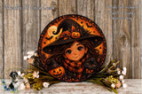 A round, decorative wreath featuring a young girl in a witch's hat, a jack-o-lantern, and a black cat, surrounded by flowers and a wooden background.