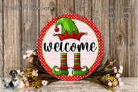 a festive welcome sign with a green elf hat and red and green striped boots, surrounded by a floral arrangement and a wooden background.