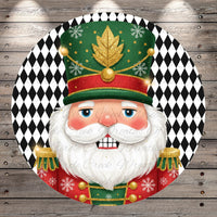 A close-up of a smiling nutcracker figure wearing a green hat with gold accents and red and gold epaulettes, set against a black and white diamond patterned background.