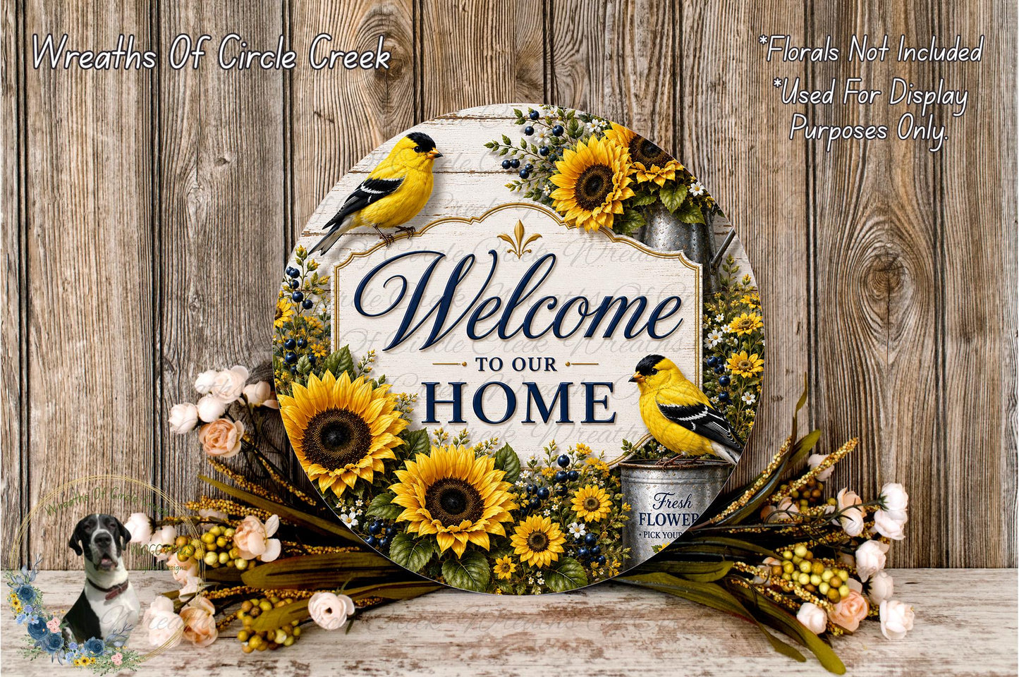 A decorative sign with the text "Welcome to our Home" surrounded by sunflowers and birds, placed on a wooden surface.