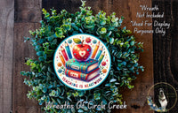 a wreath with a book and apple on it