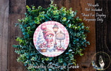 A wreath made of green foliage and featuring a snowman and a sign that says "Happy Holidays".
