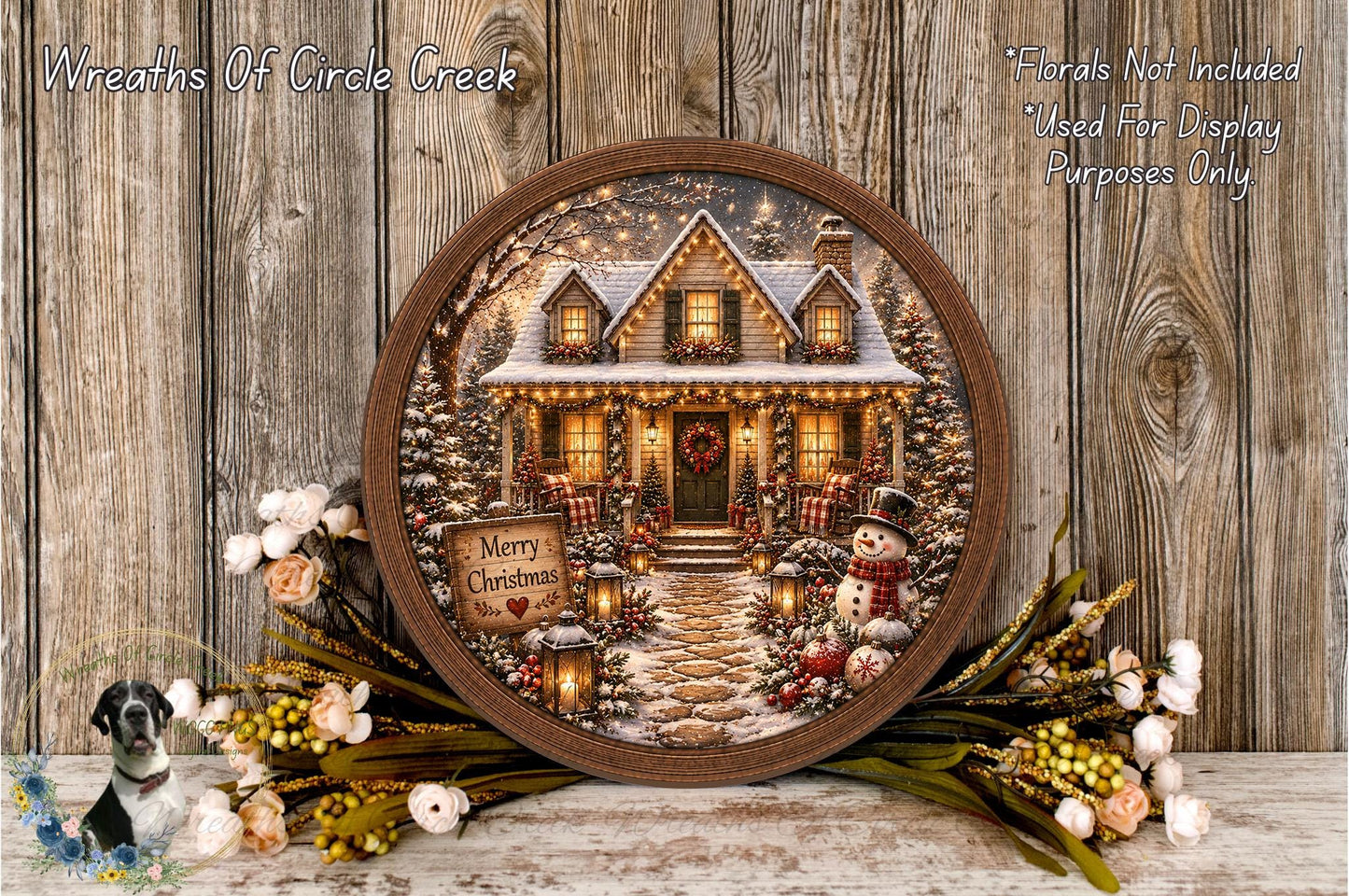 A round wooden frame displays a winter scene with a house, snowman, and Christmas decorations, surrounded by flowers and greenery.