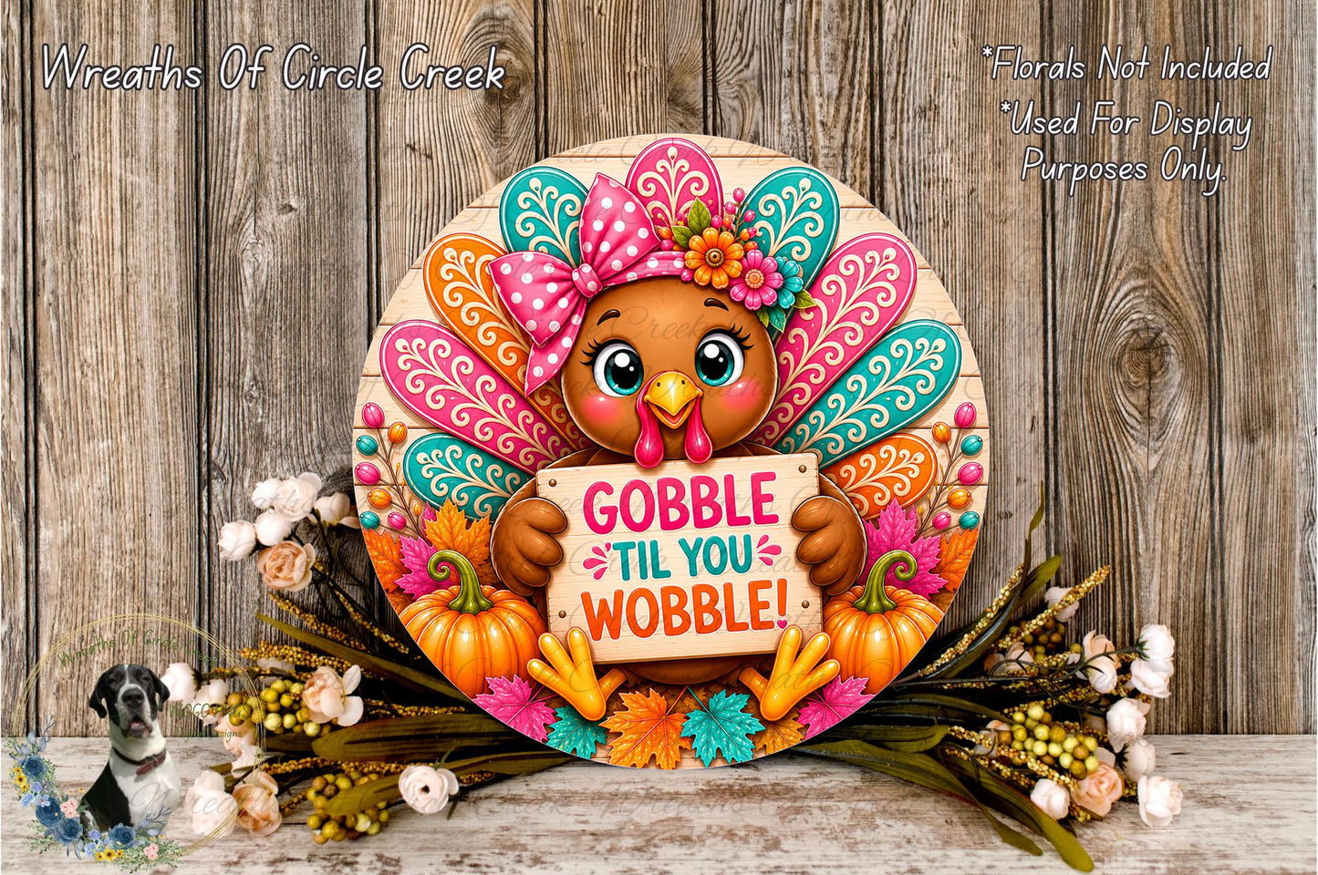 A decorative Thanksgiving wreath with a turkey holding a sign that says "GOBBLE TIL YOU WOBBLE!" surrounded by fall foliage and flowers.