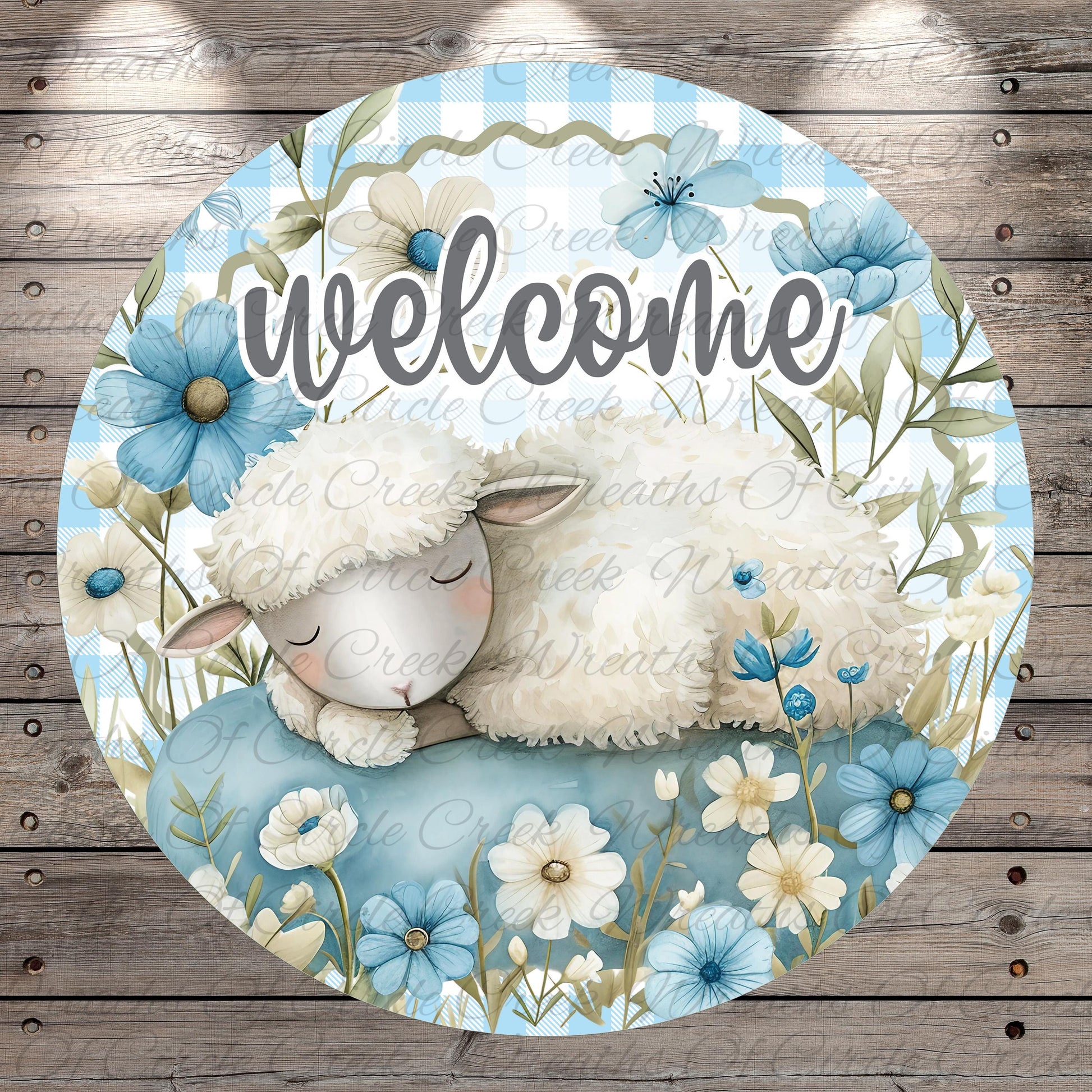 A round, decorative sign featuring a sleeping lamb surrounded by blue flowers and greenery.