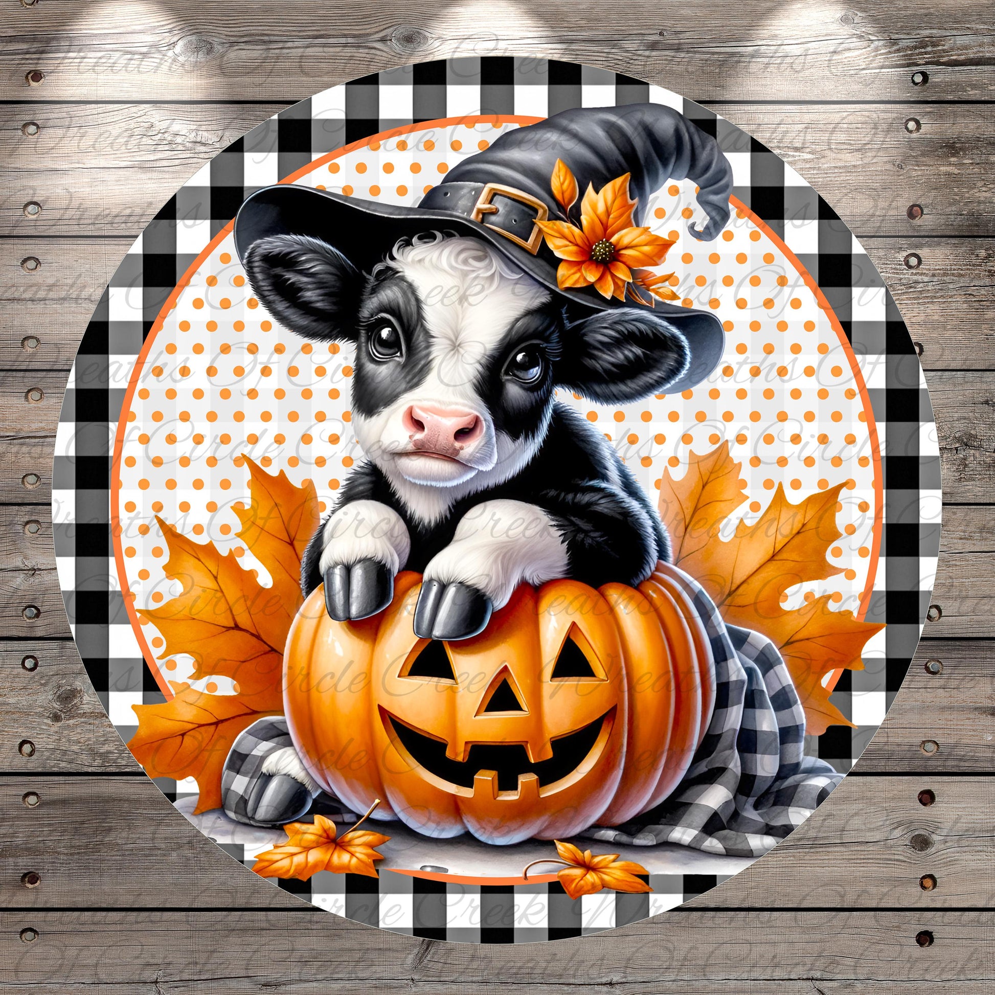 A black and white cow wearing a witch's hat sits atop a carved pumpkin, surrounded by autumn leaves, against a wooden background with a checkered pattern.