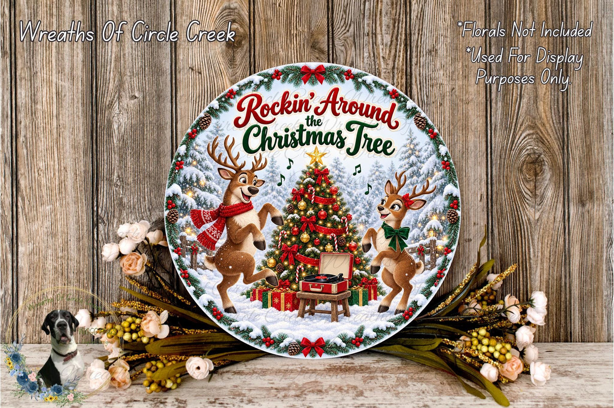 A decorative plate featuring a Christmas tree with two reindeer, surrounded by flowers and a wreath, against a wooden background.