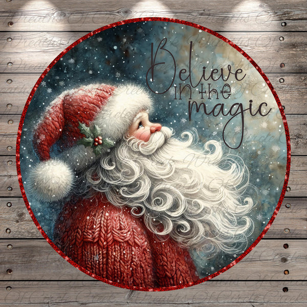Santa Claus with a long white beard blowing a kiss, surrounded by snowflakes and the text "Believe in the magic"