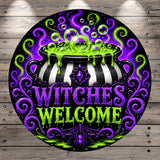 A circular sign with a black and white striped pot with bubbling green liquid, surrounded by swirling purple and green patterns. The text "WITCHES WELCOME" is prominently displayed in the center of the sign.