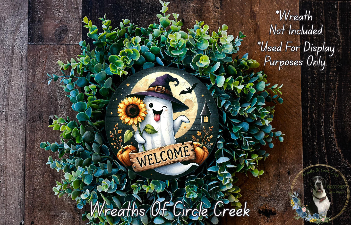 A wreath made of green foliage and featuring a ghost wearing a witch's hat, holding a sunflower and a banner that says "Welcome".
