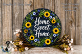 A decorative wreath with the text "Home Sweet Home" surrounded by various flowers, including sunflowers and daisies, placed on a wooden surface.