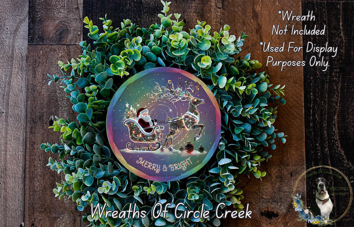 A festive wreath made of green foliage and featuring a Santa Claus sleigh pulled by reindeer, with a colorful circular design in the center displaying the text "Merry & Bright".