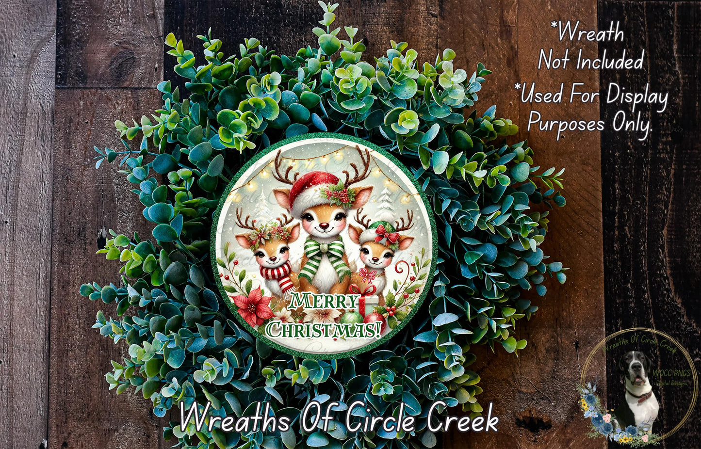 A Christmas wreath made of green foliage and featuring three cartoon reindeer wearing Santa hats and scarves. The wreath has a "Merry Christmas!" message on it.