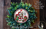 A wreath made of green leaves and a Santa Claus figurine, with the text "I Believe Santa Paws" and "Wreaths of Circle Creek" displayed on it.