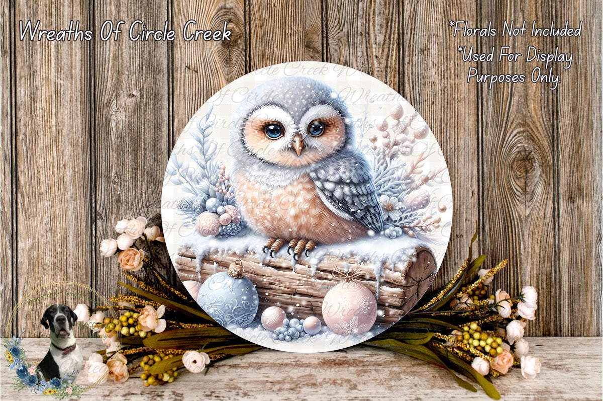 A round wooden plaque featuring a detailed illustration of an owl perched on a log, surrounded by snow and flowers.