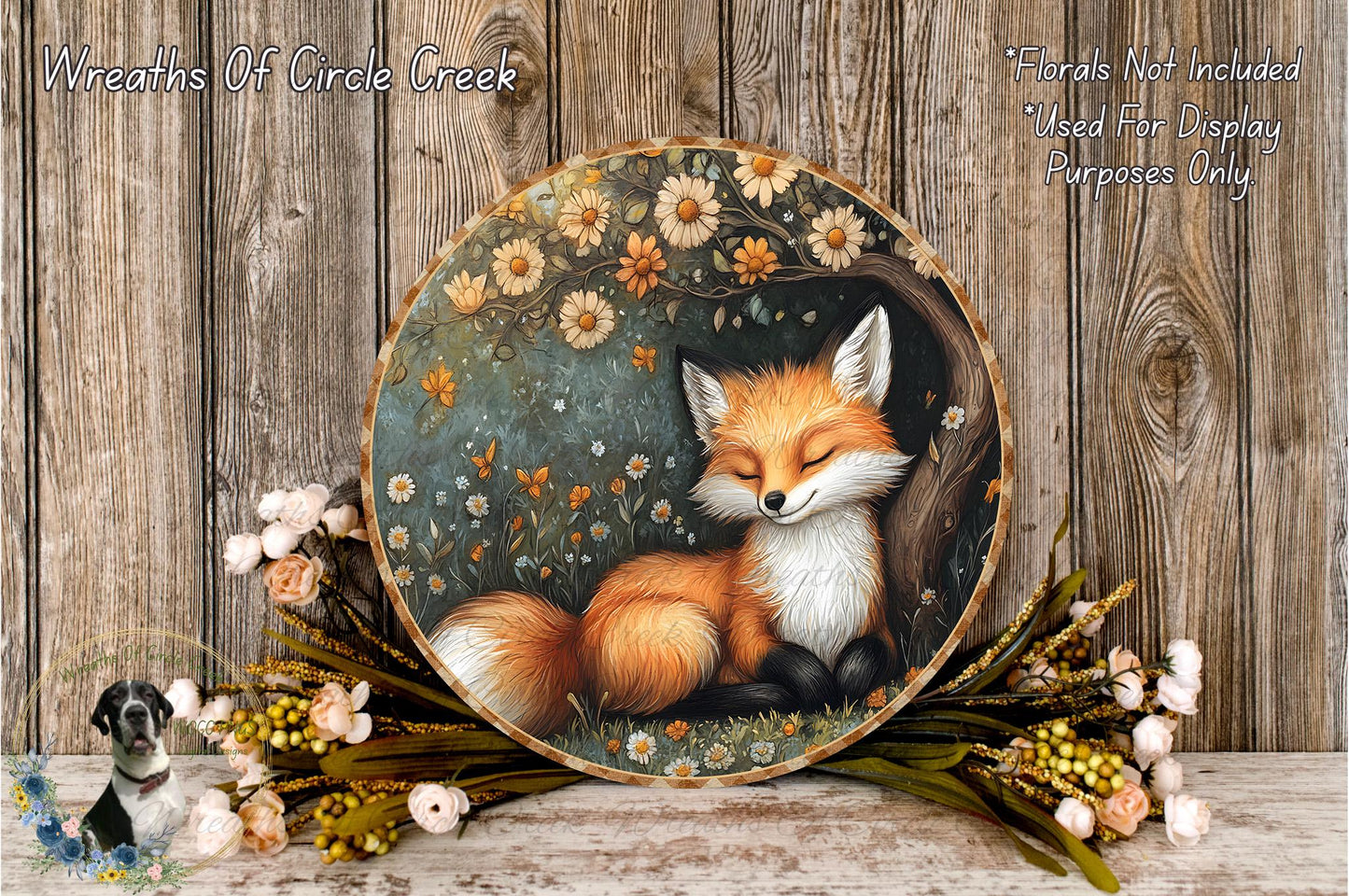 A round wooden plaque with a painting of a sleeping fox surrounded by flowers and greenery.