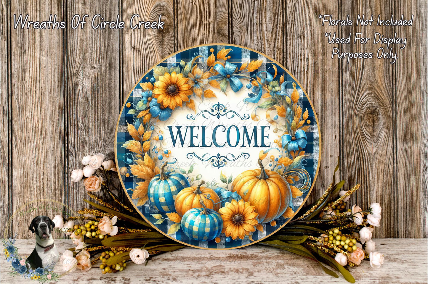 a decorative welcome sign with a floral design, surrounded by pumpkins, sunflowers, and other fall-themed elements. The sign is placed on a wooden surface, with a wreath of flowers and pumpkins nearby.