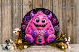 A whimsical, cartoonish monster with horns and a big smile is sitting in front of a pink gumball machine, surrounded by flowers and a wooden background.