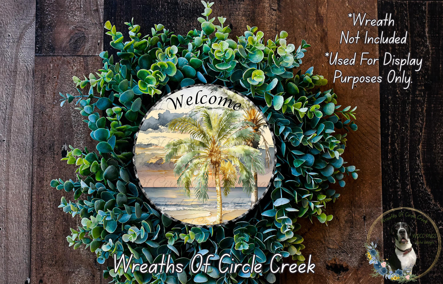 a wreath with a tropical palm tree design, surrounded by various green foliage. The wreath is displayed on a wooden surface, and there is a text overlay that reads "Welcome Wreath Not Included * Used For Display Purposes Only" and "Wreaths Of Circle Creek".