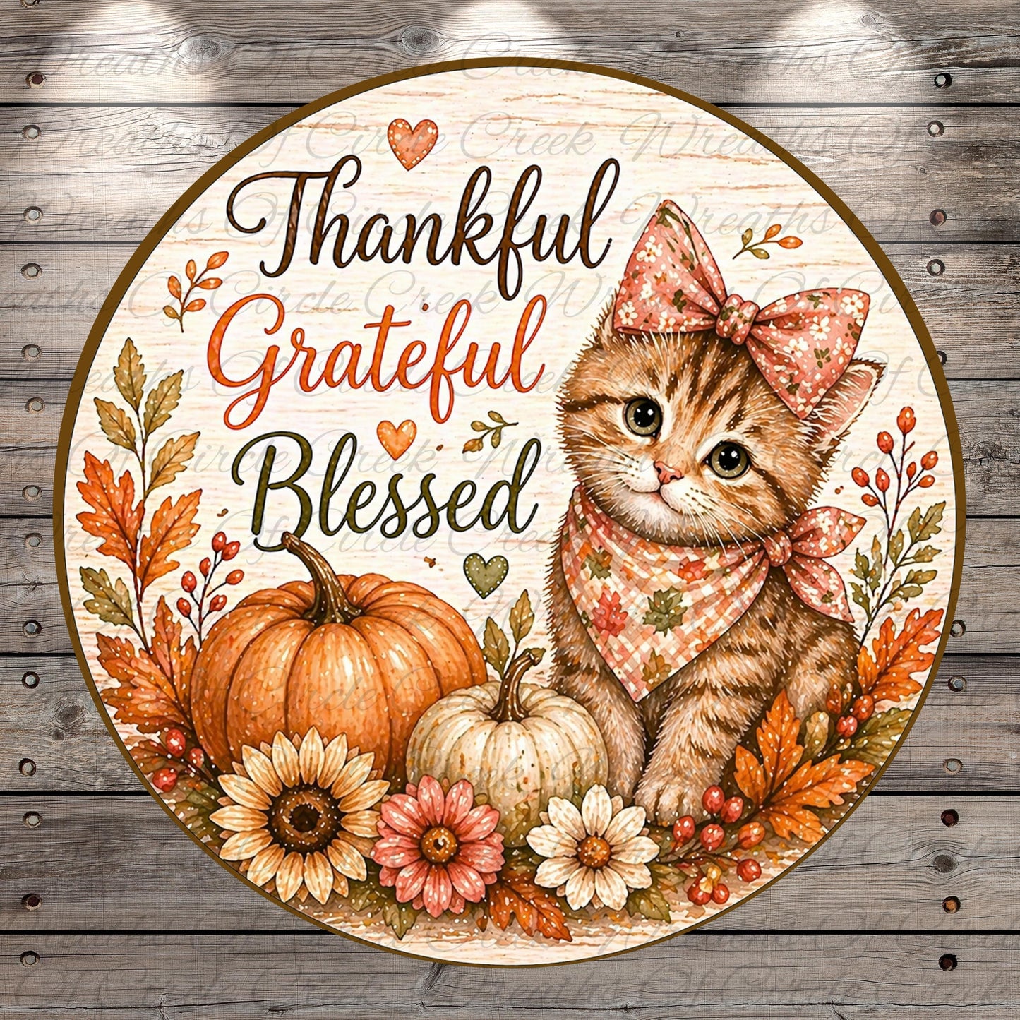 A round, wooden sign with a cat wearing a bow and surrounded by autumn-themed elements such as pumpkins, flowers, and leaves. The sign has the text "Thankful, Grateful, Blessed" written on it.