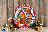 A large, colorful gingerbread house decoration with candy and flowers is displayed on a wooden surface.
